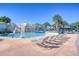 Community pool area showcasing a unique waterfall feature, palm trees and inviting lounge chairs at 5313 Sanderling Ridge Dr, Lithia, FL 33547