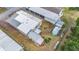 An aerial view of the home shows the roof, the yard with sheds and the neighborhood at 5524 Betmar Dr, Zephyrhills, FL 33542