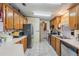 Functional kitchen featuring stainless steel appliances, white tile floor, and wood cabinets at 5524 Betmar Dr, Zephyrhills, FL 33542