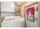 Practical laundry room with white washer and dryer and storage shelves at 5524 Betmar Dr, Zephyrhills, FL 33542