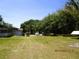 Expansive lot featuring lush trees, various vehicles, and outbuildings on a sunny day at 5602 N Dormany Rd, Plant City, FL 33565