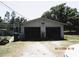 Exterior view of a two-car garage with mature trees, offering parking and storage solutions at 5602 N Dormany Rd, Plant City, FL 33565