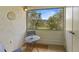 Cozy screened in balcony with seating and a view of lush greenery and mature trees at 621 Duchess Blvd, Dunedin, FL 34698