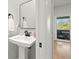 Bright bathroom featuring a pedestal sink and sliding door at 621 Duchess Blvd, Dunedin, FL 34698