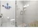 The modern bathroom features a glass shower, neutral tile, and coastal decor at 621 Duchess Blvd, Dunedin, FL 34698