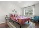 Bright bedroom with large window, hardwood floors, area rug and decorative flower wall hangings at 621 Duchess Blvd, Dunedin, FL 34698