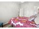 Neutral bedroom with wood floors, a floral comforter, and closet with white doors at 621 Duchess Blvd, Dunedin, FL 34698