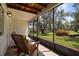 Charming screened porch with rocking chairs and views of the well-maintained backyard at 621 Duchess Blvd, Dunedin, FL 34698