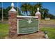 Dunedin Golf Club sign with a brick pillar entrance, manicured lawns, and mature palm trees at 621 Duchess Blvd, Dunedin, FL 34698
