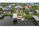 Stunning aerial view of a waterfront home with a private dock, boat lift, pool, and lush landscaping at 633 Soundview Dr, Palm Harbor, FL 34683