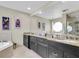 Spacious bathroom featuring double sinks with granite countertops, a soaking tub, and modern fixtures at 633 Soundview Dr, Palm Harbor, FL 34683