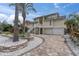 Two-story yellow home with two-car garage, landscaped yard and white staircase at 633 Soundview Dr, Palm Harbor, FL 34683