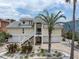 Stunning two-story coastal home with lush tropical landscaping and a welcoming elevated front entry at 633 Soundview Dr, Palm Harbor, FL 34683