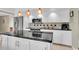 Well-lit kitchen featuring an island, black countertops, and stainless steel appliances at 633 Soundview Dr, Palm Harbor, FL 34683