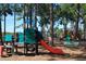 Community playground with slides, swings, and climbing structures in a natural, wooded setting at 633 Soundview Dr, Palm Harbor, FL 34683