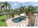 Private backyard pool area featuring a brick patio, tropical landscaping, and comfortable lounge seating at 633 Soundview Dr, Palm Harbor, FL 34683