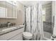 Bathroom featuring a vanity with granite countertop and tub-shower with decorative curtain at 6627 Main St, New Port Richey, FL 34653
