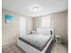 Bedroom features a large window, comfortable bed and tile flooring at 6627 Main St, New Port Richey, FL 34653