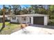 Charming single-story home featuring a one-car garage and a well-maintained front yard with mature trees at 7926 Gulf Way, Hudson, FL 34667