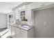 Bright kitchen featuring white cabinets, granite countertops, subway tile backsplash, and stainless steel sink at 7926 Gulf Way, Hudson, FL 34667