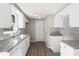 Well-lit kitchen featuring white cabinets, granite countertops, subway tile backsplash, and stainless steel sink at 7926 Gulf Way, Hudson, FL 34667