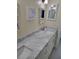 Bathroom featuring elegant vanity with marble countertops, a decorative mirror and a walk-in shower at 9035 37Th N St, Pinellas Park, FL 33782