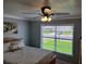 Comfortable bedroom with ceiling fan, window view and a bed with floral pillows at 9035 37Th N St, Pinellas Park, FL 33782