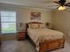 Sunlit bedroom featuring a floral-patterned comforter, ceiling fan and view to the outdoors at 9035 37Th N St, Pinellas Park, FL 33782