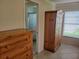 Bedroom with a wooden cabinet, drawers and view of attached bathroom and window with blinds at 9035 37Th N St, Pinellas Park, FL 33782