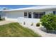 Front yard featuring a pristine white exterior, a well manicured lawn, and blue shutters at 9035 37Th N St, Pinellas Park, FL 33782