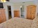 Main bedroom with wood furniture, a floral bedspread, and access to other rooms at 9035 37Th N St, Pinellas Park, FL 33782