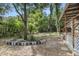 Spacious backyard area with mature trees, patio steps, and wood perimeter at 9132 Mango St, New Port Richey, FL 34654