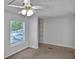 Cozy bedroom featuring a window, ceiling fan, and closet space, ideal for comfort and storage at 9132 Mango St, New Port Richey, FL 34654