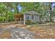 Cozy gray home featuring a covered porch and mature trees, providing a peaceful and shaded environment at 9132 Mango St, New Port Richey, FL 34654