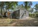 Gray house with wooden steps and a clothesline, in a setting with abundant foliage at 9132 Mango St, New Port Richey, FL 34654