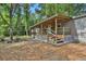 Home exterior showing a porch, steps, and lawn with mature trees at 9132 Mango St, New Port Richey, FL 34654