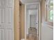 Bright hallway featuring wood-look floors, an open door to closet, and access to a bedroom with closet at 9132 Mango St, New Port Richey, FL 34654