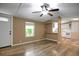 Open-concept living room featuring a ceiling fan, light wood-look floors, and a pass-through to the kitchen at 9132 Mango St, New Port Richey, FL 34654