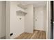 Utility room with white walls, wooden floors, shelves and door to another room at 9132 Mango St, New Port Richey, FL 34654