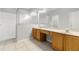 Well-lit bathroom with double sinks, a large mirror, and a separate shower area at 9818 White Barn Way, Riverview, FL 33569