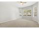 Bright bedroom featuring neutral walls and carpet, a ceiling fan and multiple windows at 9818 White Barn Way, Riverview, FL 33569