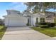 Charming home features a gray roof, an attached two-car garage, and mature landscaping at 9818 White Barn Way, Riverview, FL 33569