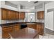 Well-lit kitchen featuring wooden cabinets, a center island, and dark countertops at 9818 White Barn Way, Riverview, FL 33569
