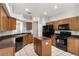 Functional kitchen with wooden cabinets, black appliances, and a center island at 9818 White Barn Way, Riverview, FL 33569