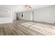 Open-concept living area with wood-look flooring, featuring a ceiling fan and ample natural light for a welcoming atmosphere at 9818 White Barn Way, Riverview, FL 33569