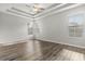 Relaxing main bedroom with a tray ceiling, wood floors, and multiple windows at 9818 White Barn Way, Riverview, FL 33569