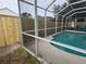 A fenced pool area is shown, surrounded by new wood fence and screen enclosure, perfect for privacy and outdoor enjoyment at 9818 White Barn Way, Riverview, FL 33569