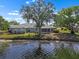 Backyard view of the lake and home with an enclosed patio at 1002 Strawpocket Pl, Sun City Center, FL 33573