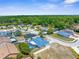 An aerial view of house in neighborhood surrounded by tall trees and a pond at 10119 Briar Cir, Hudson, FL 34667
