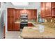 Stylish kitchen featuring wooden cabinets, granite countertops, and stainless-steel appliances at 10119 Briar Cir, Hudson, FL 34667